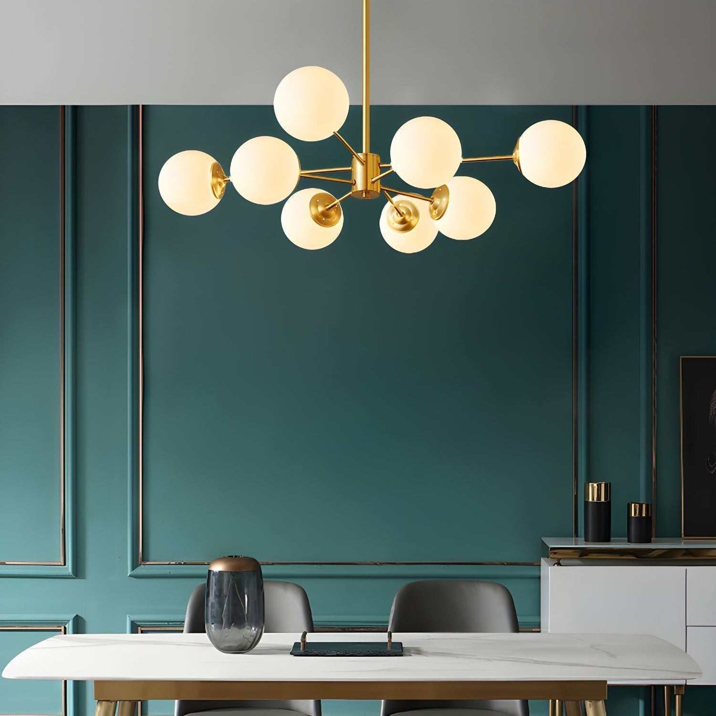 Gold 8-light globe pendant light chandelier with frosted glass shades, hanging over a dining table.