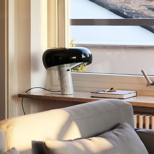 Post-modern marble desk lamp in black on a window ledge.