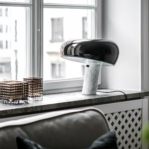 Stylish post-modern marble desk lamp in black and white on a windowsill, featuring a sleek contemporary design.