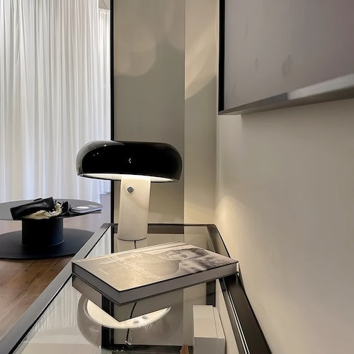 Stylish black post-modern marble desk lamp on glass table in contemporary living area.