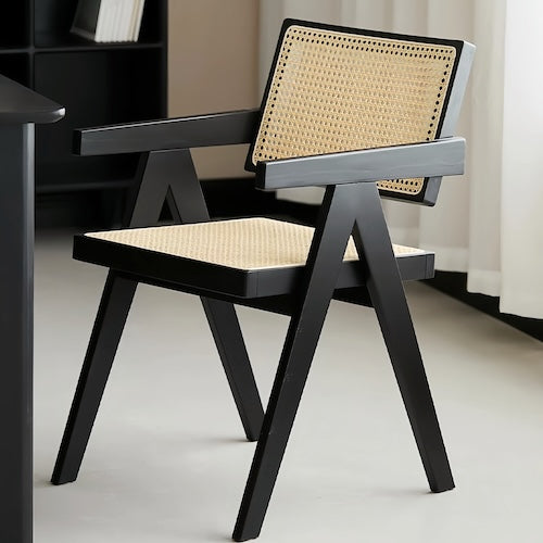 Minimalist modern rattan chair with inverted V-shaped legs and hand-woven seat.