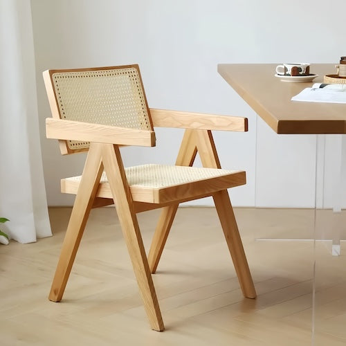 Natural rattan chair with wooden frame and V-shaped legs for elegant relaxation.