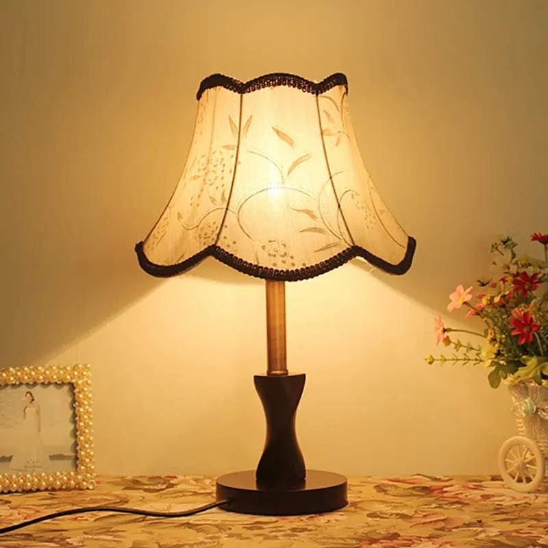 Wooden Table Lamp with hand-woven fabric shade illuminating a living room setting.