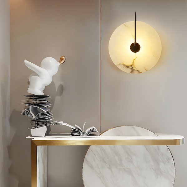 Marble Sconce Wall Light illuminating modern decor with gold and black accents.
