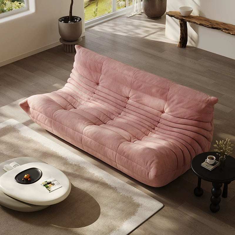 Togo 3-seater pink corduroy couch in modern living room.