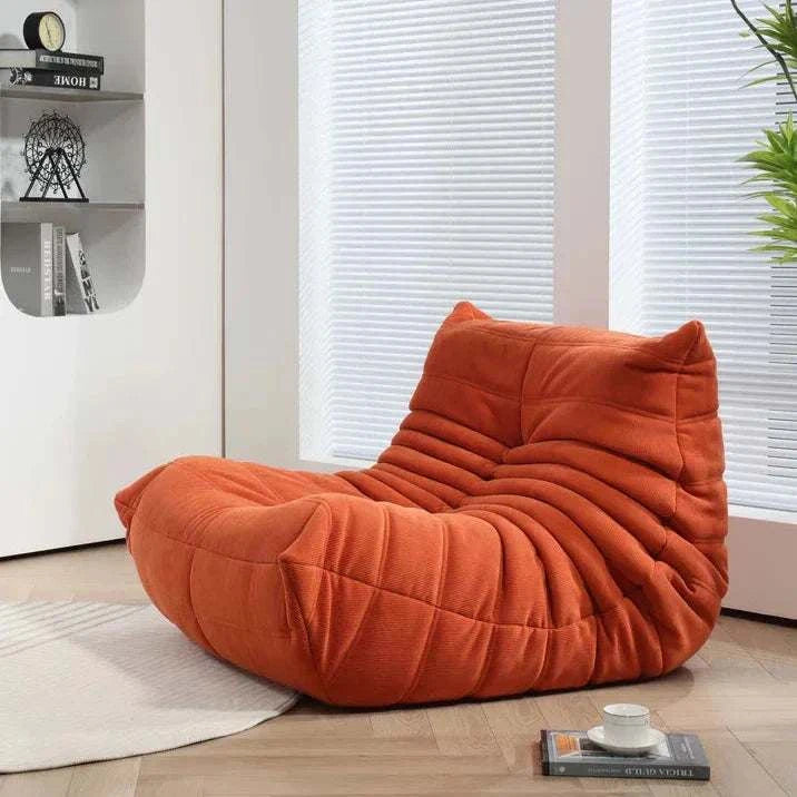 Togo Chair in a modern living room setting, featuring high-density foam and premium fabric for ultimate comfort and style.