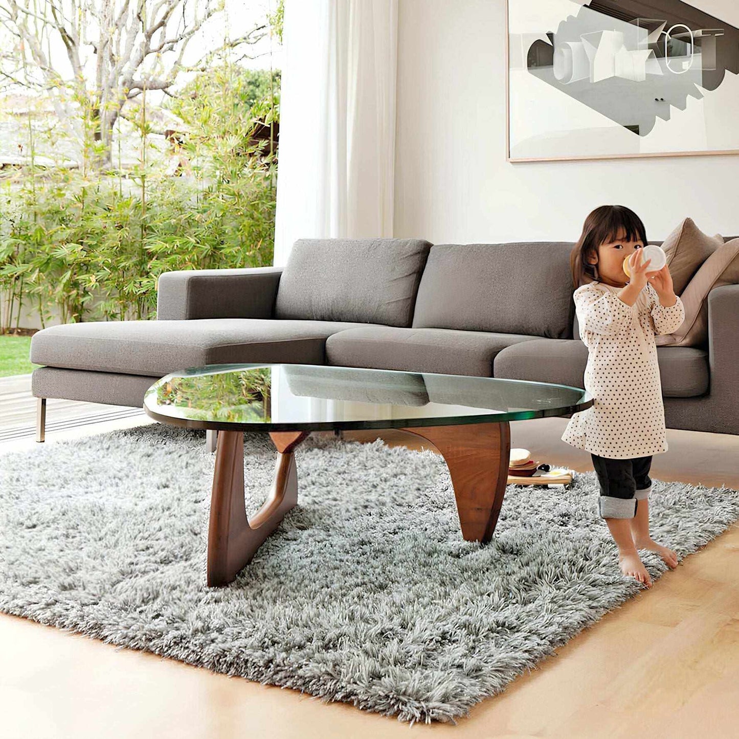 Noguchi Coffee Table Replica with interlocking wood base and glass top in living room setting.