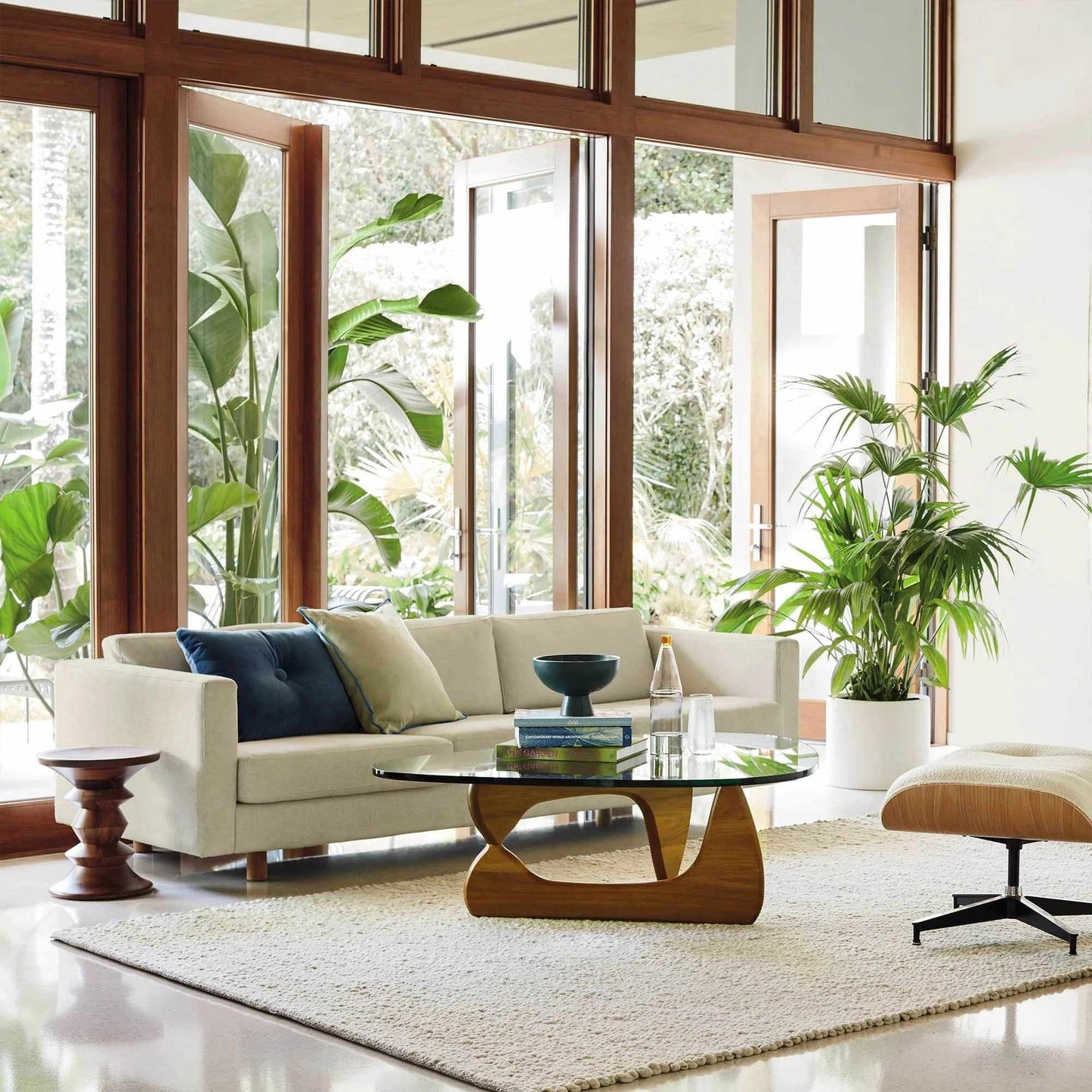 Noguchi Coffee Table in modern living room with glass top and wooden base.