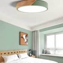 Modern LED macaroon flush mount ceiling light with wooden accent in a stylish bedroom.