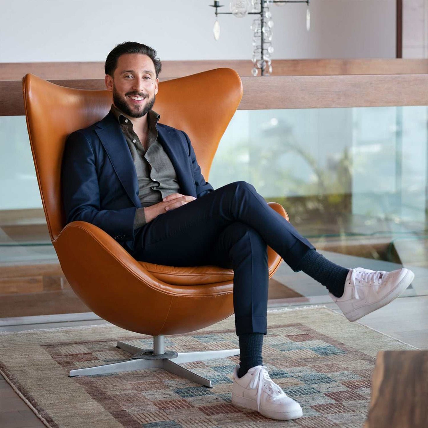 Iconic brown Egg Chair with ottoman, mid-century modern design, featuring sleek lines and premium materials in a sophisticated interior.