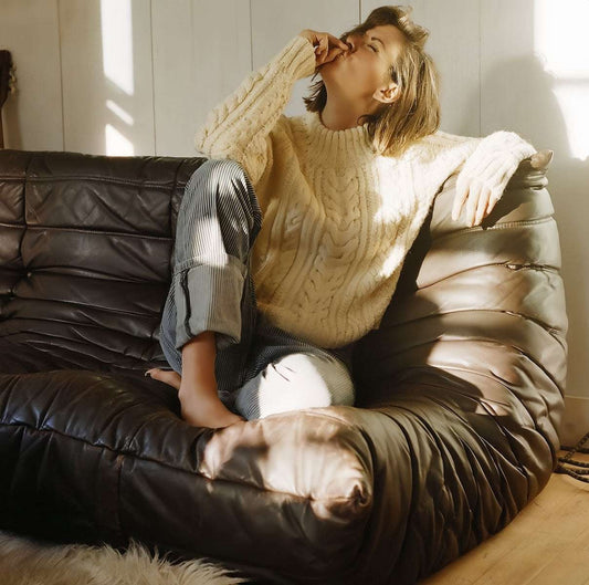 Ligne Roset Togo Replica Sofa in oil wax leather with person relaxing, showcasing comfort and timeless design - orangme.com