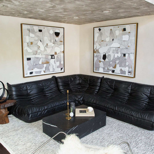 TOGO Black Leather Sofa in stylish living room setting with modern art.