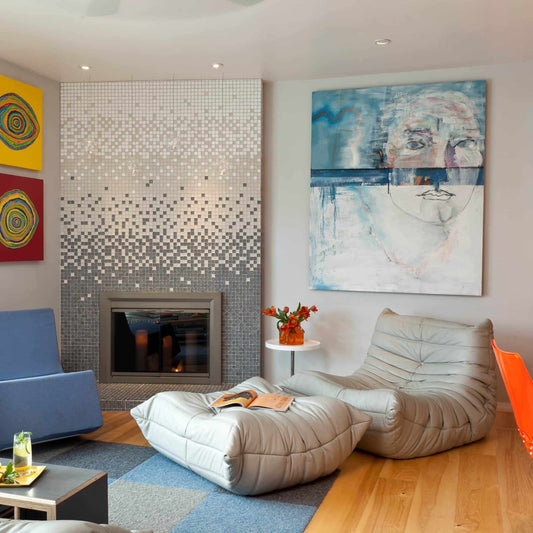 Togo Fireside Chair and Foot Stool in modern living room with artwork and mosaic fireplace - orangme.com